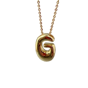 Polished gold 3D initial G letter pendant necklace for women on a white background