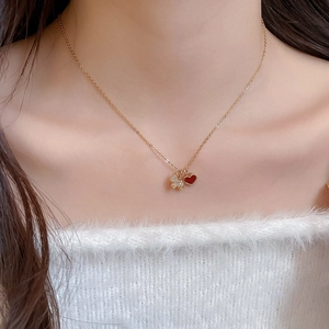 Détail du collier doré avec cœur rouge et pendentif chiot en zircon brillant sur un mannequin