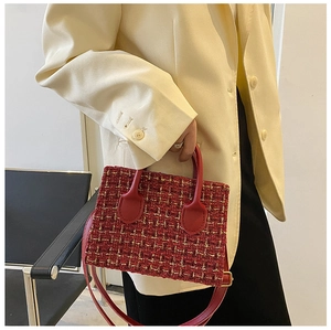 Detail of red tweed handbag showing textured fabric and stylish top handle design