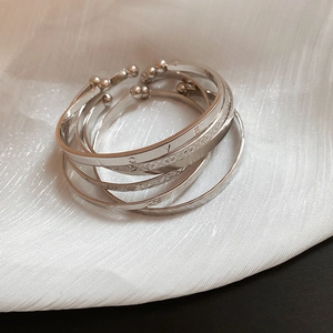 Macro detail of silver minimalist bracelets with LOVE engravings and embossed patterns