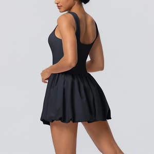 Detail of a black athletic tennis dress with U-shaped back and pleated bubble hem