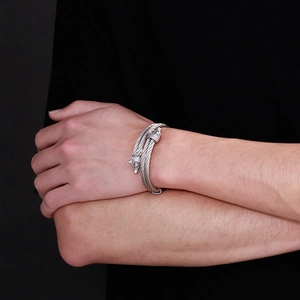 Close-up of double-headed wolf stainless steel braided rope bracelet on a male wrist