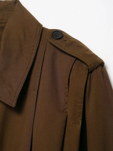 Detailed macro view of twill cotton jacket shoulder straps and black resin button detail