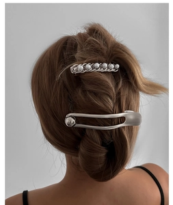 Detail of silver hairpins with elegant pearls and minimalist textured alloy design