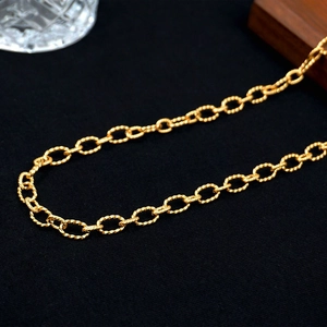 Minimalist golden stainless steel twisted rope chain necklace on black texture background