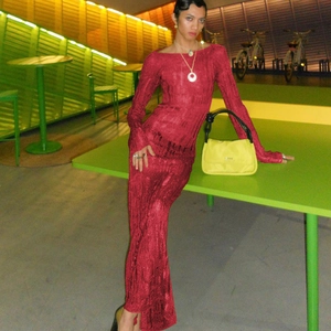 Detail of red slim fit knitted long sleeve dress showing textured fabric on female model
