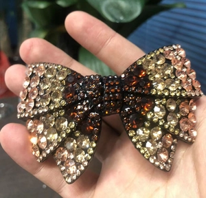 Detailed view of handmade bow hair clip with amber and champagne rhinestones