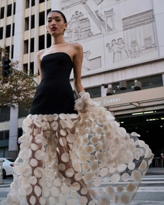 Close-up of elegant strapless black bodice with white 3D floral polka dot tulle skirt