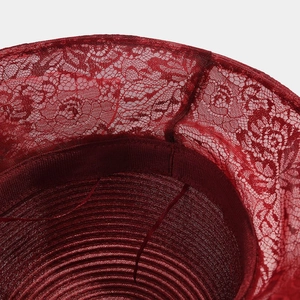 Detail of burgundy sun hat featuring floral lace brim and spiral woven texture inside