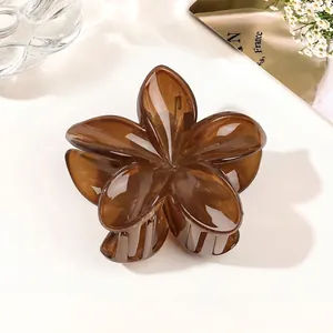 Macro detail of a translucent dark brown flower hair claw clip with a glossy finish