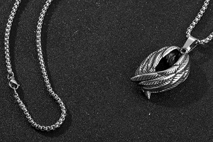 Vue détaillée du pendentif aile d'ange en acier inoxydable sur chaîne vénitienne