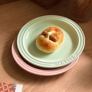 Stacked mint green and pink ceramic bear plates featuring Good Day embossed text