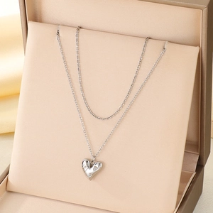 Collier double couche argenté avec pendentif cœur présenté dans un écrin cadeau beige