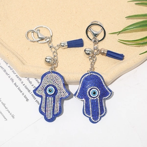Close-up of Hamsa Hand keychains with Evil Eye rhinestones and matching blue tassels