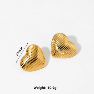Close-up of golden heart earrings featuring a fine 3D ribbed texture and metal luster