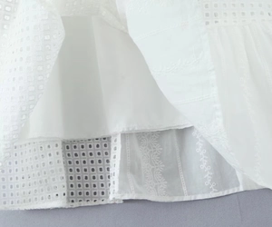 Dettaglio in cotone bianco con ricamo a occhiello e strati di pizzo sovrapposti