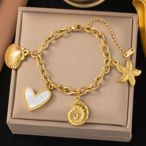 Gold-plated stainless steel charm bracelet with shell and starfish pendants on a gift box