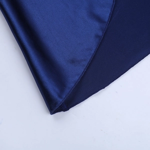 Détail de la robe bleu marine montrant le contraste entre satin et maille côtelée