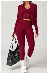 Détail d'un ensemble de yoga rouge foncé avec manches à passe-pouce et leggings de compression