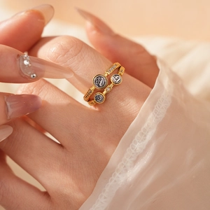 Gros plan d'une bague vintage dorée avec zircons sur une main avec de la dentelle