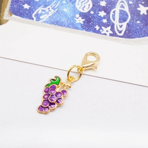 Macro detail of purple grape pendant with gold lobster clasp and enamel finish