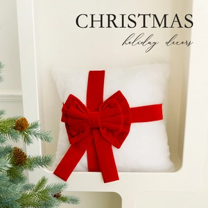 White plush Christmas pillow with large red velvet bow for festive home decoration