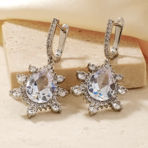 Sparkling silver snowflake earrings with a central teardrop stone and round diamonds