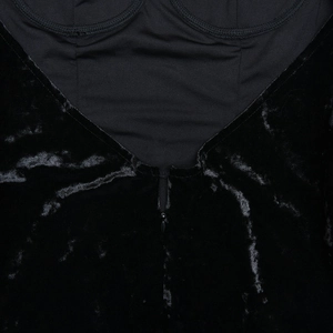 Detail of invisible zipper on the back of a black velvet bodycon mini dress