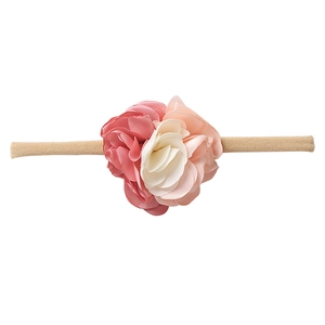 Close-up of pink and beige nylon floral headbands with soft elastic texture for infants