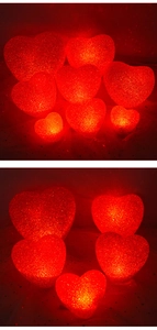 Close-up of red heart-shaped LED lights with textured surface and soft warm glow