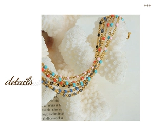 Close-up of golden multi-layered chain with colorful enamel beads on coral decor