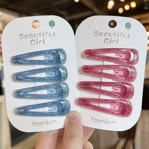 Macro detail of glitter hair clips in pink and blue on display cards with crown logo