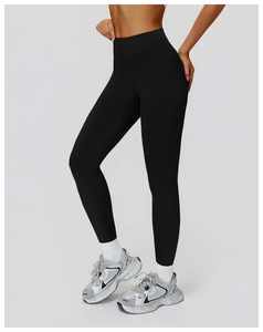 Detail of black high-waisted yoga pants with white crew socks and silver sneakers