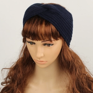 Detail of dark blue knitted headband showing textured fabric and front cross knot design
