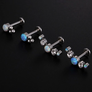 Makroaufnahme von 16G Titan-Labret-Steckern mit weißen und blauen Opalen und Kristallen