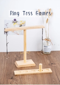 Close-up of wooden ring toss game with score ladder and metal hooks on a desktop