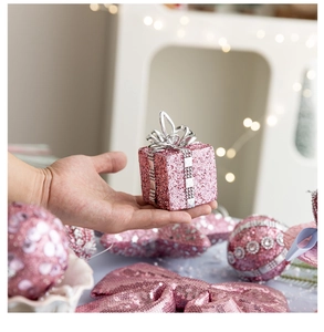 Close-up of pink foam Christmas gift box ornament with glitter and silver ribbon detail