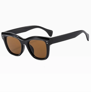 Detail view of black square frame sunglasses with brown lenses and metal dot accents