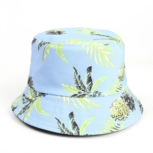 Detail of light blue bucket hat featuring yellow pineapple and tropical palm leaf patterns