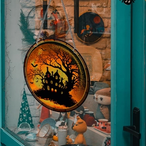 Macro detail of Halloween acrylic pendant with haunted house and bats on iron chain