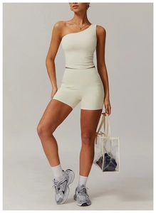 Détail du haut de sport à une épaule blanc cassé et du short de yoga taille haute