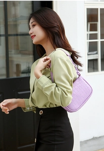 Detail of lavender crocodile embossed hobo bag with matching thick chain shoulder strap