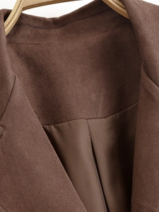 Detail of brown faux suede trench coat collar featuring smooth satin lining texture