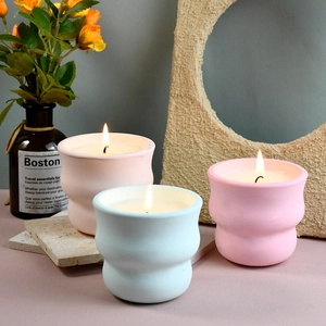 Coppe per candele estetiche opache in rosa e verde presentate con candele accese