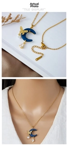 Detail view of steel necklace with blue moon pendant, butterfly, pearl, and zircon