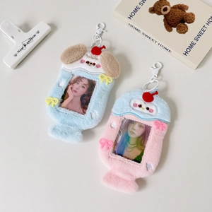 Detail of blue and pink puppy-shaped plush photo card holders with cherry and bow accents