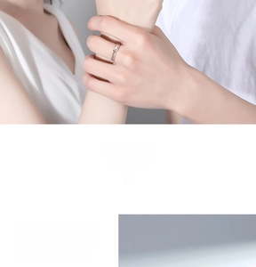 Close-up of adjustable silver couple ring featuring an embossed cross and textured edges