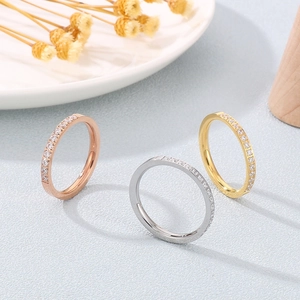 Close-up of three sparkling eternity rings in gold, silver and rose gold with pavé stones