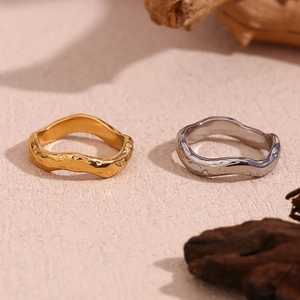 Detailed close-up of gold and silver rings with unique hammered wavy texture surfaces