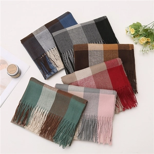 Flat lay of colorful plaid scarves with soft fringes and cozy lifestyle props